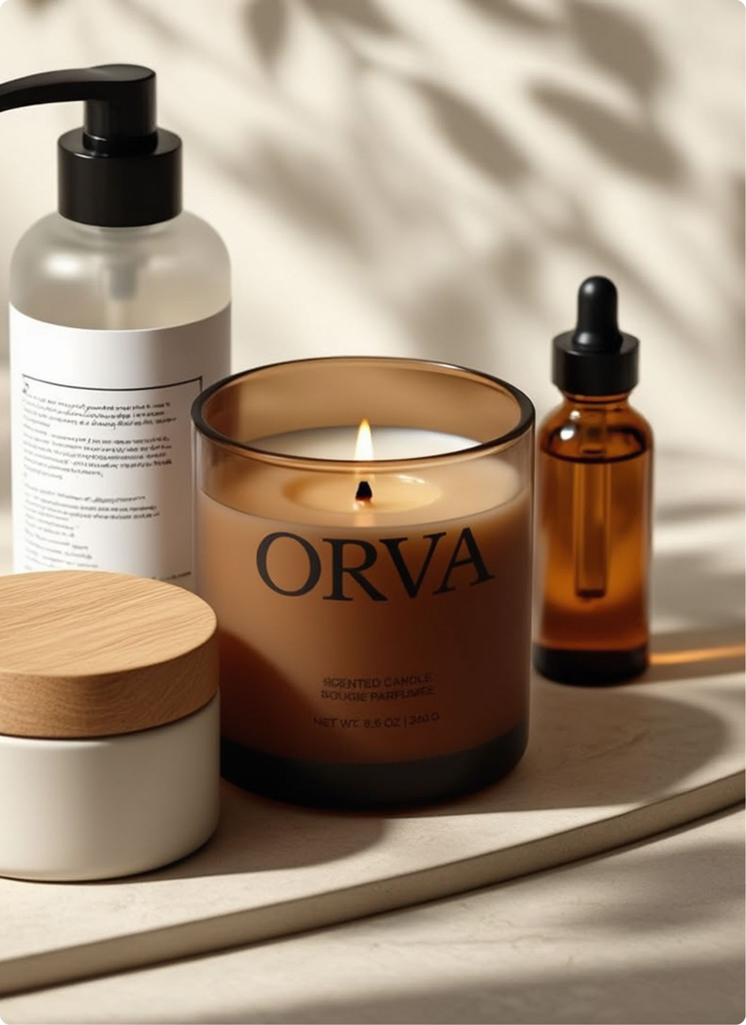 A lit ORVA scented candle sits on a light surface, surrounded by a pump bottle, a brown dropper bottle, and a small jar with a wooden lid. Soft light and shadows create a calm, spa-like atmosphere.