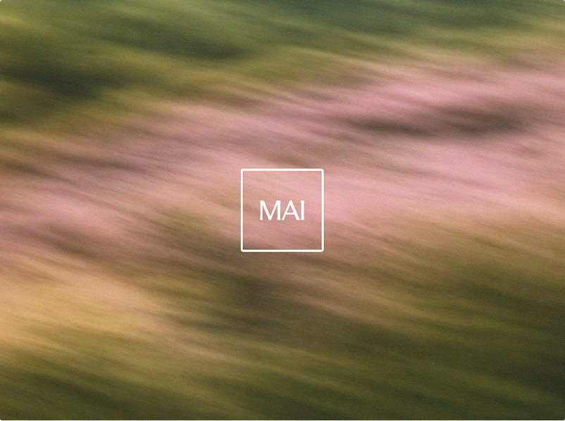 A blurry background of green and pink colors with the word "MAI" in white text centered inside a thin white square.